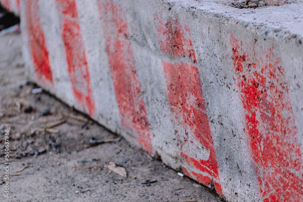 Red and white lines on a road concrete sign blocking traffic or repair.