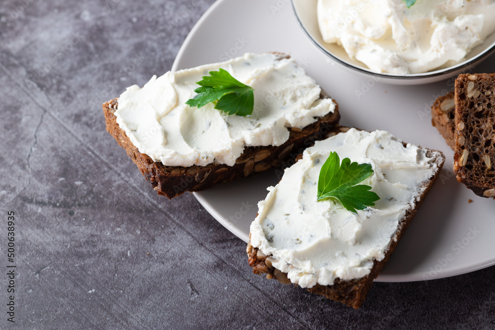 Rye bread with cream cheese on grey table. Whole grain rye bread with seeds Rye bread with cream cheese on grey table. Whole grain rye bread with seeds