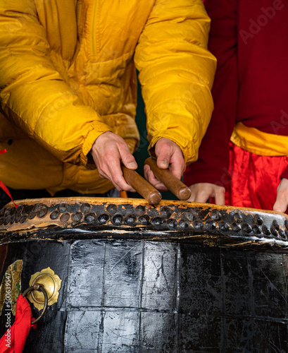 Older man drumming on large traditional asian drum during lunar new year