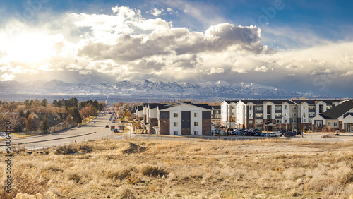 Salt Lake City, Utah Suburb Housing Development, Mountain Background with Overcast Sky next to a Main Road with Traffic © czitrox