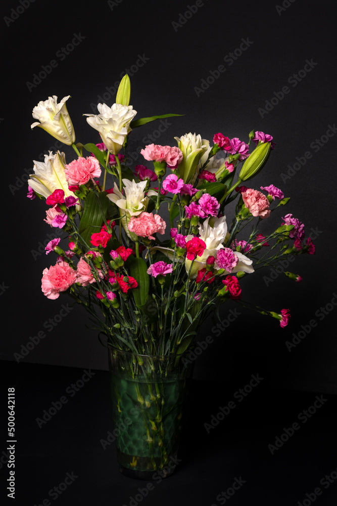 Colorful flower bouquet arrangement in vase isolated on black