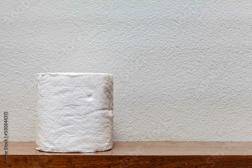 New rolls of tissue paper on a wooden shelf in the bathroom