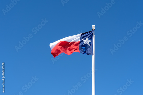 Flag of Texas waving in the wind with blue sky in the background. Texas is a state in the South Central region of the United States. 