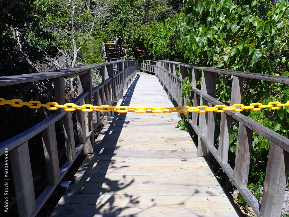 Wooden footbridge blocked by yellow chain