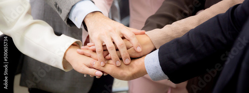 Closeup group of business team harmony with man and woman joining hands stack together in enterprise for victory and success, teamwork of partnership with meeting and cheering, deal and agreement.
