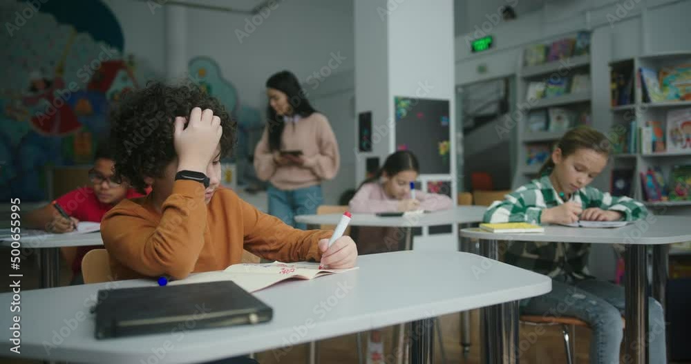 Asian teacher uses tablet checking learning process of kids Asian teacher uses tablet checking learning process of kids