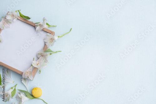 Wooden plate with a place for your texts and delicate white flowers on a light background.
