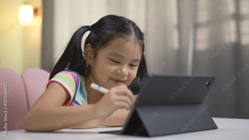 asian child student studying online class on computer or kid girl enjoy smiling writing or art drawing by touch pen on tablet screen to video call learning write or person happy learn from home school