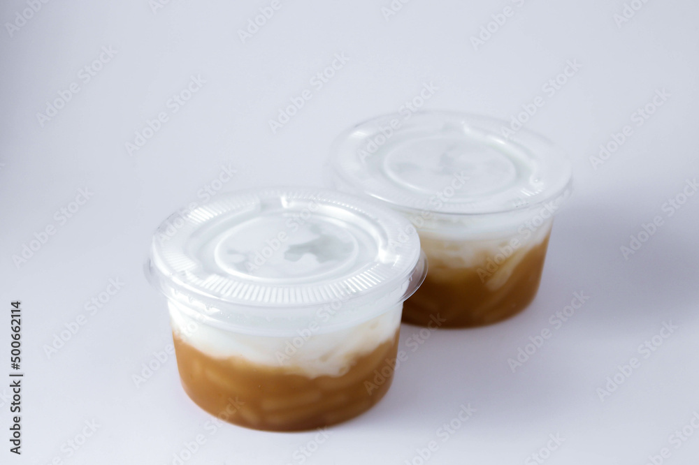 Sweet Rice Noodles with Coconut Cream in a plastic cup on a white table. Sweet Rice Noodles with Coconut Cream in a plastic cup on a white table.