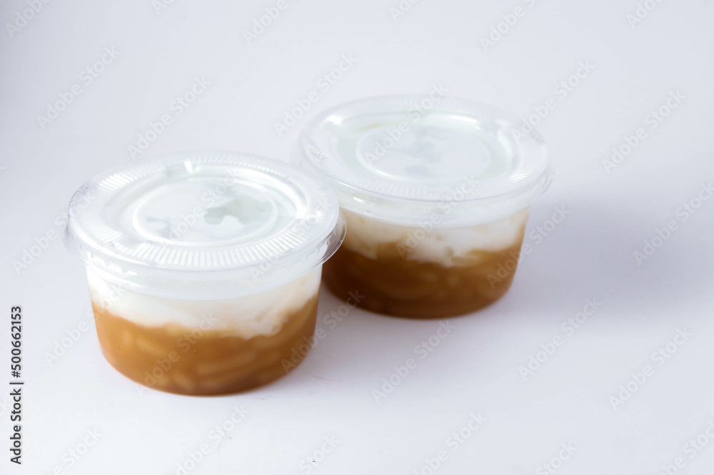 Sweet Rice Noodles with Coconut Cream in a plastic cup on a white table. Sweet Rice Noodles with Coconut Cream in a plastic cup on a white table.