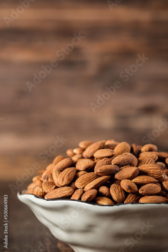 Almonds in wood bowl on wood table.Diet raw material © weedezign
