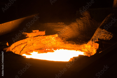 Closeup of glowing hot liqud metal in furnace photo