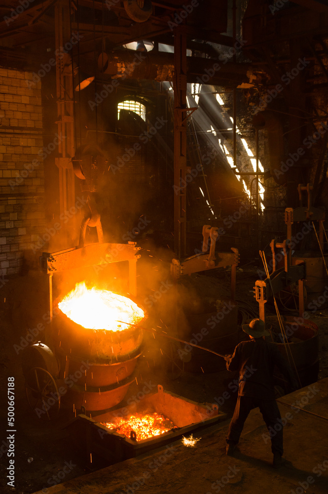 Metallurgist removing slack from hot molten metal