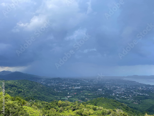 Perfect landscape. Panorama  seascape  view from above. Thunderstorms coming  beautiful thundercloud on the sky. Sea  green forest  town at the valley. Summer storm. Rainy weather. Spring and rain.