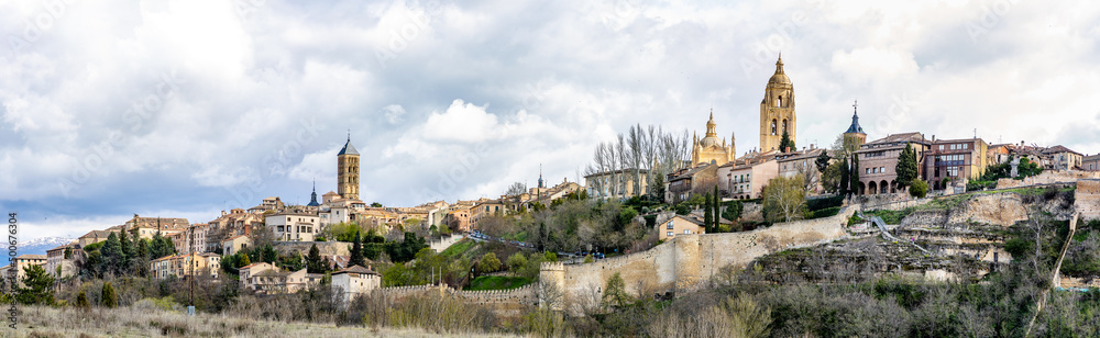 views of the historic buildings in the streets of Segovia with tourists walking under its streets in Segovia
