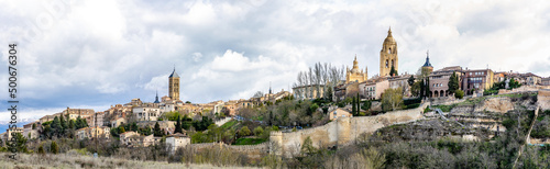 views of the historic buildings in the streets of Segovia with tourists walking under its streets in Segovia