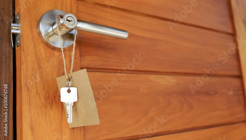 Wooden door is opened and key hanging outside.