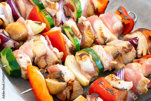 Lightly roasted turkey shish kebab on metal skewers, with lots of colorful veggies, ready for preparation. Delicious, light, great looking food. Getting ready for barbecue.