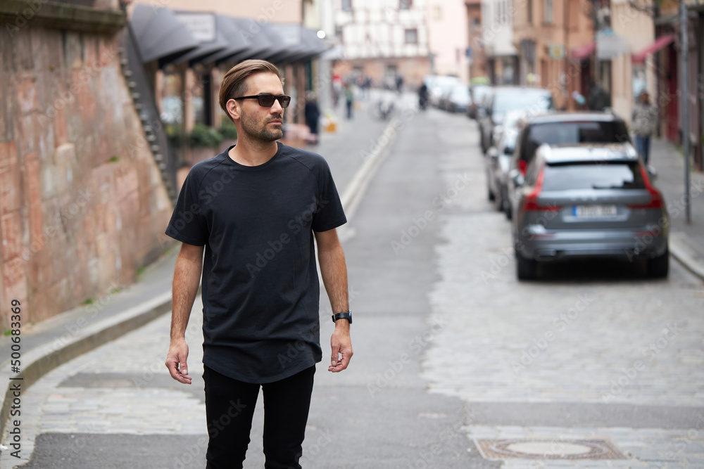 Black blank t-shirt on a hipster handsome male model with space for your logo or design in casual urban style