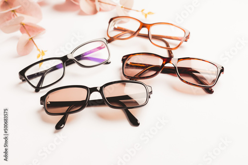 Several trendy stylish glasses on white background with copy space