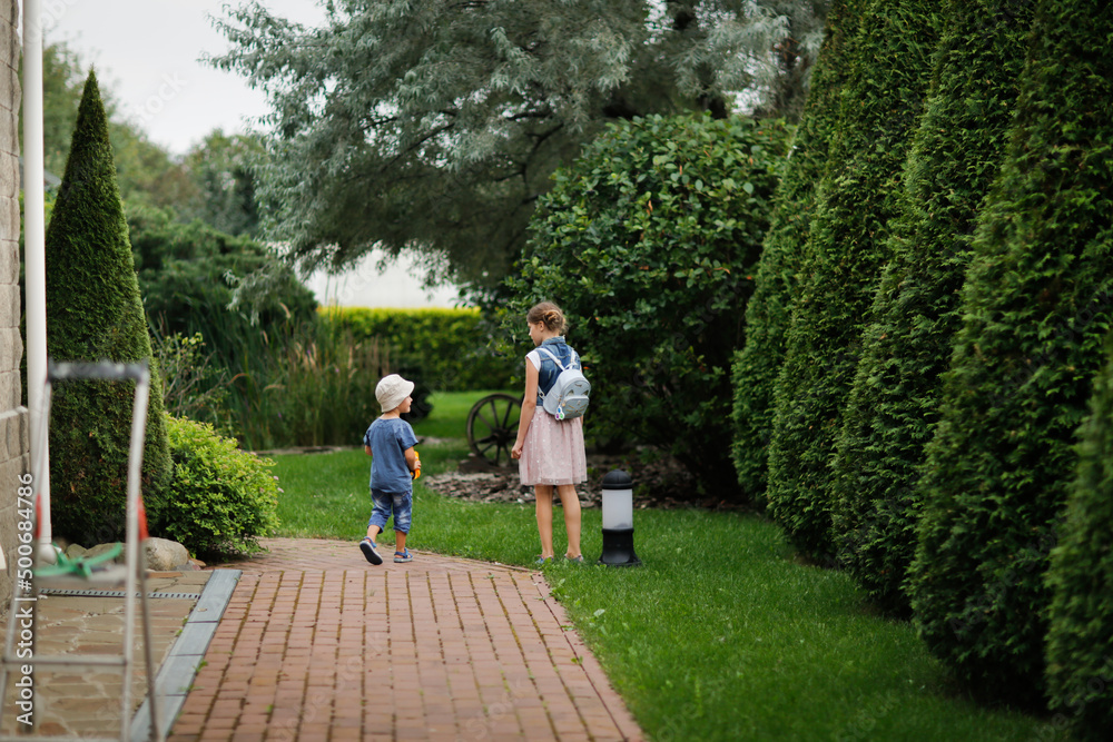 brother and sister sibling children walking in the garden, landscape and topiary art, English garden and children