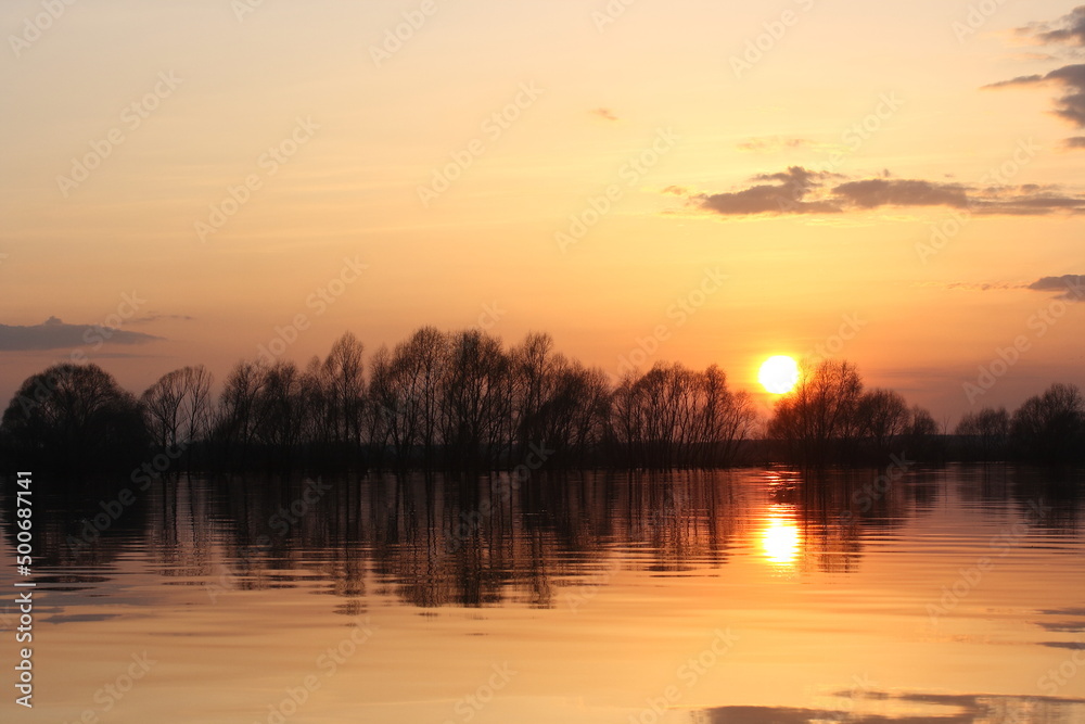View of the flooded river in spring at sunset