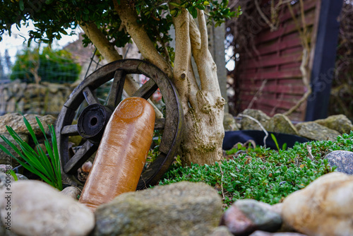 wheel and old ceramic bottle in the garden