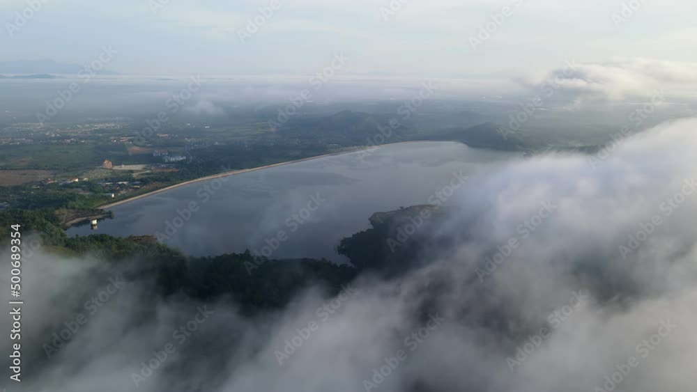 Aerial move over fog cloud flow at the forest cover Mengkuang dam Aerial move over fog cloud flow at the forest cover Mengkuang dam