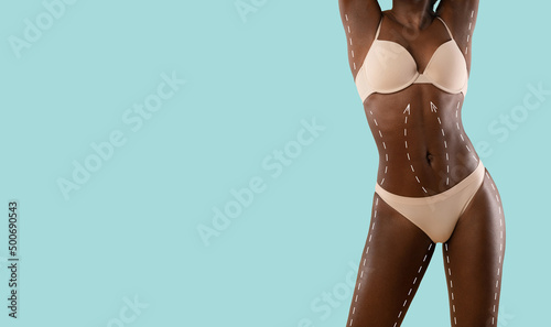 Beautiful black lady posing in beige underwear on blue, cropped