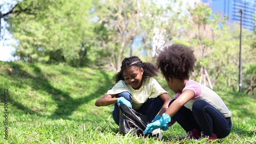 Young girls African American keep trash and cleaning waste around the park. concept of reducing global warming. garbage collection