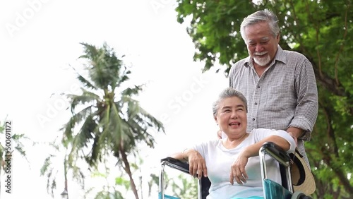 An elderly man video call on a wheelchair with his wife in the garden with fresh and happiness expression on his face. Concept of congenital disease and accident or health insurance