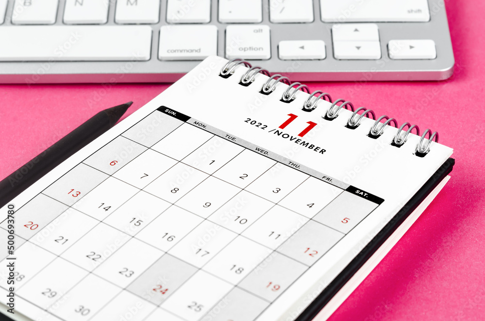 November 2022 desk calendar with pencil on pink background. November 2022 desk calendar with pencil on pink background.
