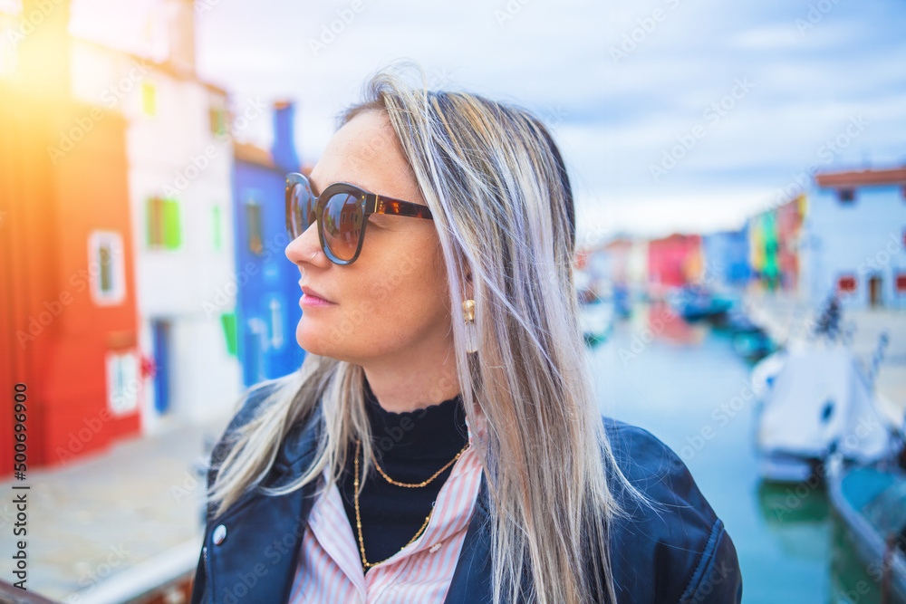Happy traveler woman having fun near colorful houses on Burano island in Venetian lagoon. Travel and vacation in Italy concept. Lifestyle travel moments in the beautiful italian city. Happy traveler woman having fun near colorful houses on Burano island in Venetian lagoon. Travel and vacation in Italy concept. Lifestyle travel moments in the beautiful italian city.