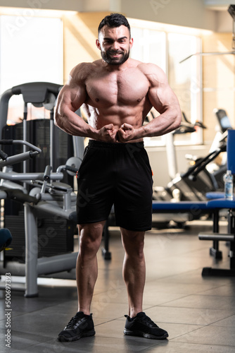 Handsome Muscular Man Flexing Muscles In Gym