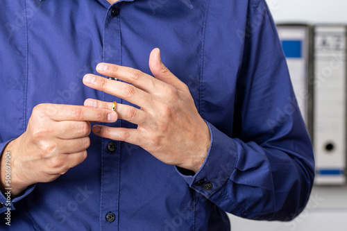 Hands of latin male who is about to taking off his wedding ring at the lawyer's office