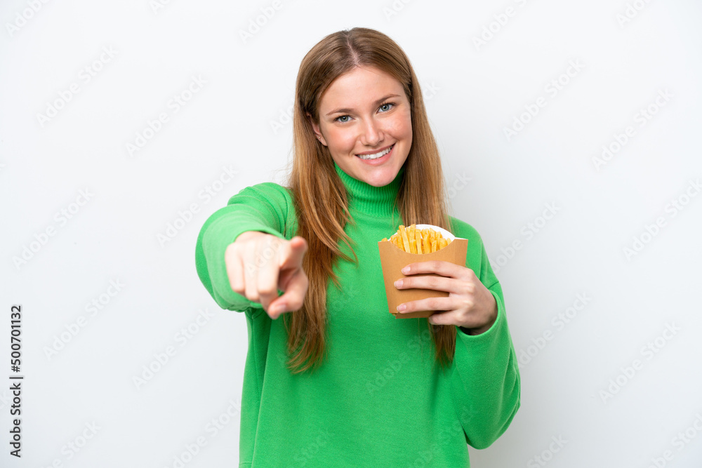 Young caucasian woman holding fried chips isolated on white background points finger at you with a confident expression Young caucasian woman holding fried chips isolated on white background points finger at you with a confident expression