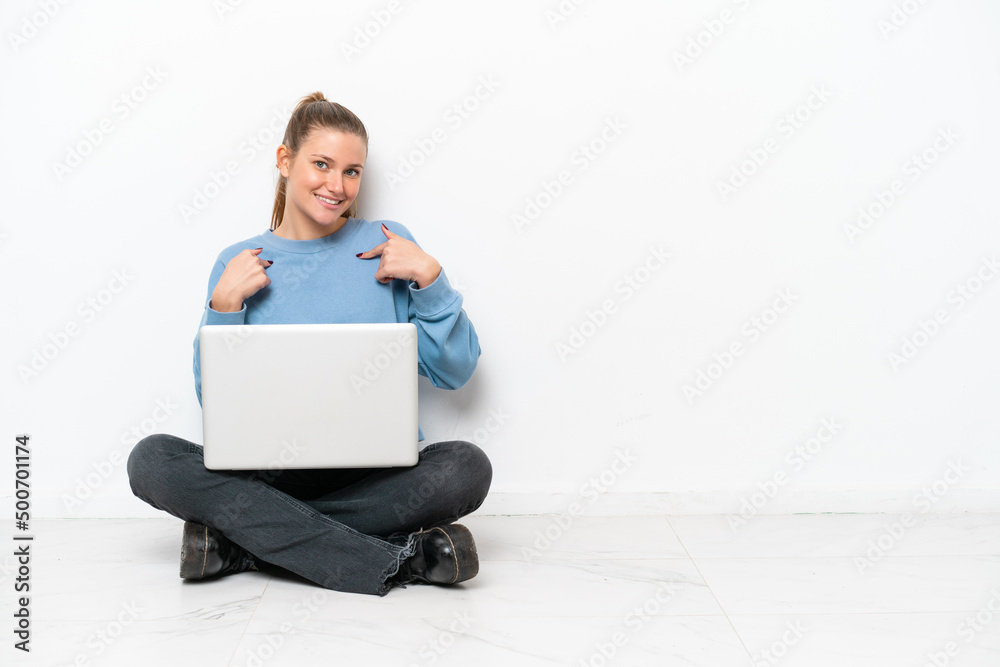 Young woman with a laptop sitting on the floor with surprise facial expression Young woman with a laptop sitting on the floor with surprise facial expression