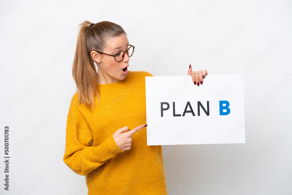 Young caucasian woman isolated on white background holding a placard with the message PLAN B with surprised expression Young caucasian woman isolated on white background holding a placard with the message PLAN B with surprised expression