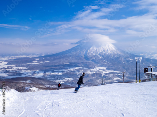 Snowy volcano with cap cloud viewed from a ski resort (Niseko Hanazono Resort, Hokkaido, Japan) photo