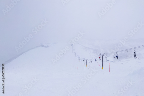 Looking down at slope in a ski resort on snowy day (Niseko Hanazono Resort, Hokkaido, Japan)