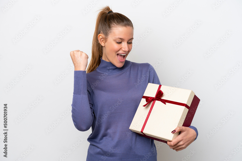 Young caucasian woman holding a gift isolated on white background celebrating a victory