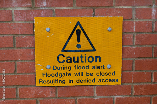 Fototapete Warning sign informing the public that is a risk of a flood, the floodgate will