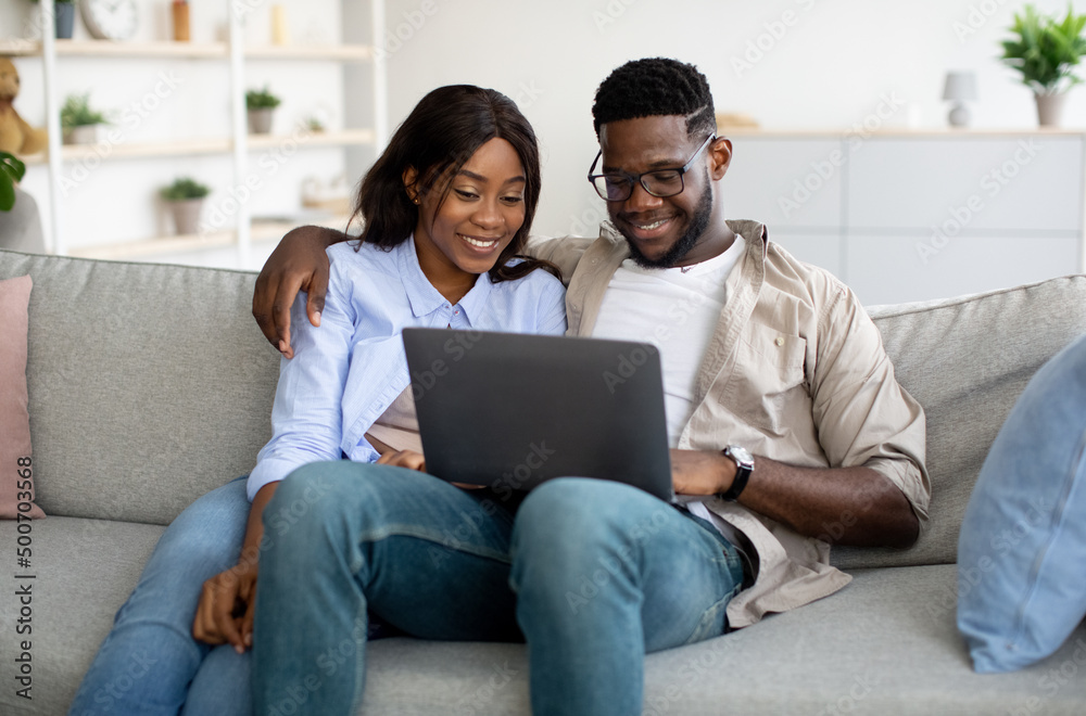 Portrait of African American couple using laptop at home Portrait of African American couple using laptop at home