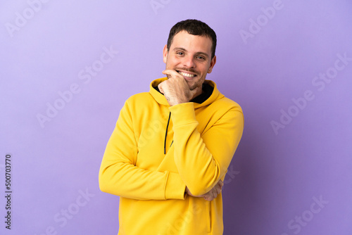 Brazilian man over isolated purple background happy and smiling