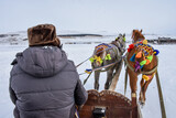 Man riding barouche with two fancy horses in winter on the frozen Çıldır Lake Ardahan in Turkey