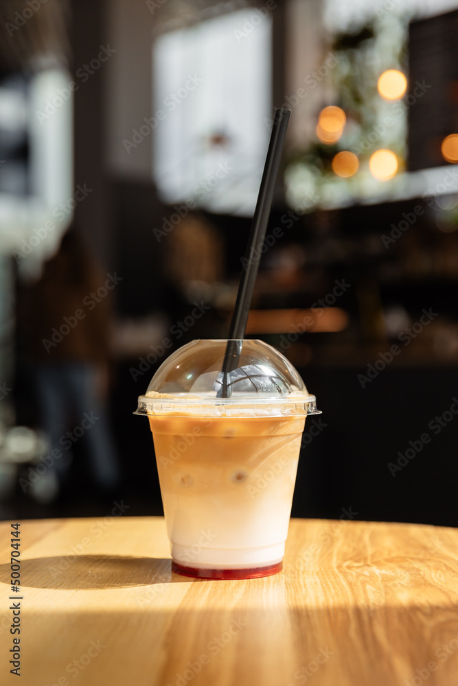 Iced coffee or latte in take away plastic cup on cafe table. Disposable  transparent plastic coffee cup. Coffee and milc coffee cocktail Stock Photo