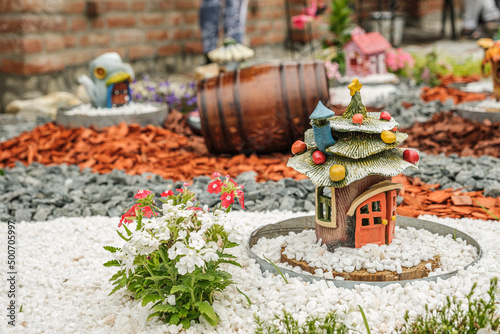 Garden arrangement with wood logs, wicker baskets, gravel and various ornaments