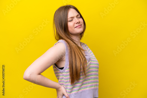 Young caucasian woman isolated on yellow background suffering from backache for having made an effort