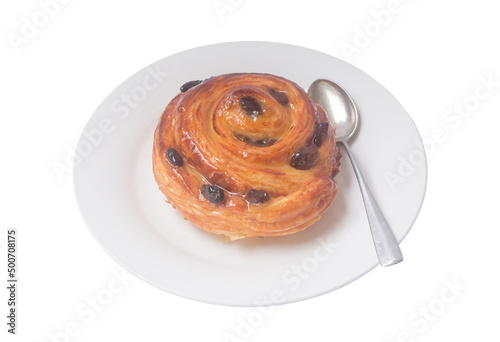 Spiral danish pastry or sweet bun with raisin on top on white plate with small teaspoon served for breakfast isolated on white background
