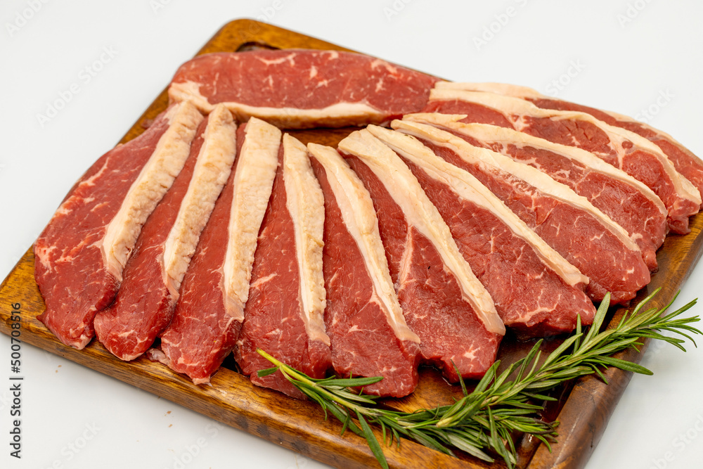 Beef fillet isolated on a white background. Raw beef tenderloin on wooden serving board. close up